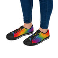 Colorful rainbow sneakers worn with blue jeans on a white background