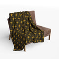 Patterned blanket draped over a brown chair on a white background