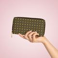 Hand holding a wallet with a floral pattern against a pink background