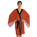 Woman wearing a red patterned robe with a black belt on a white background