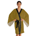 Woman wearing a yellow patterned robe with a black belt on a white background