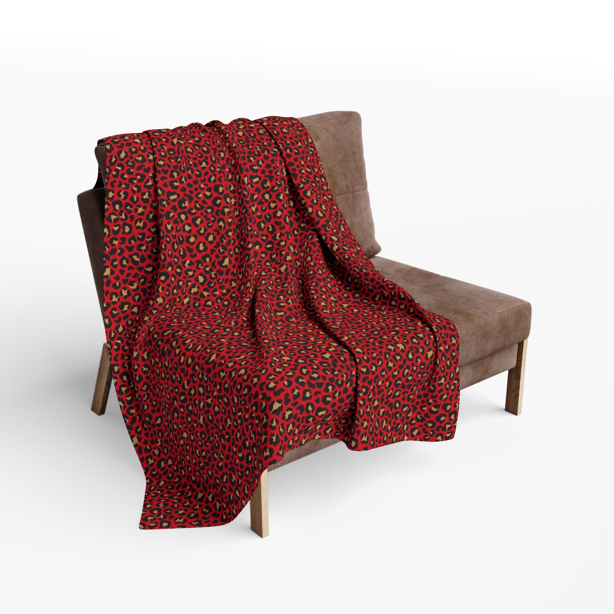 Red leopard print blanket draped over a brown chair on a white background