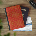 Red patterned passport cover, passport, and airplane tickets on a wooden surface