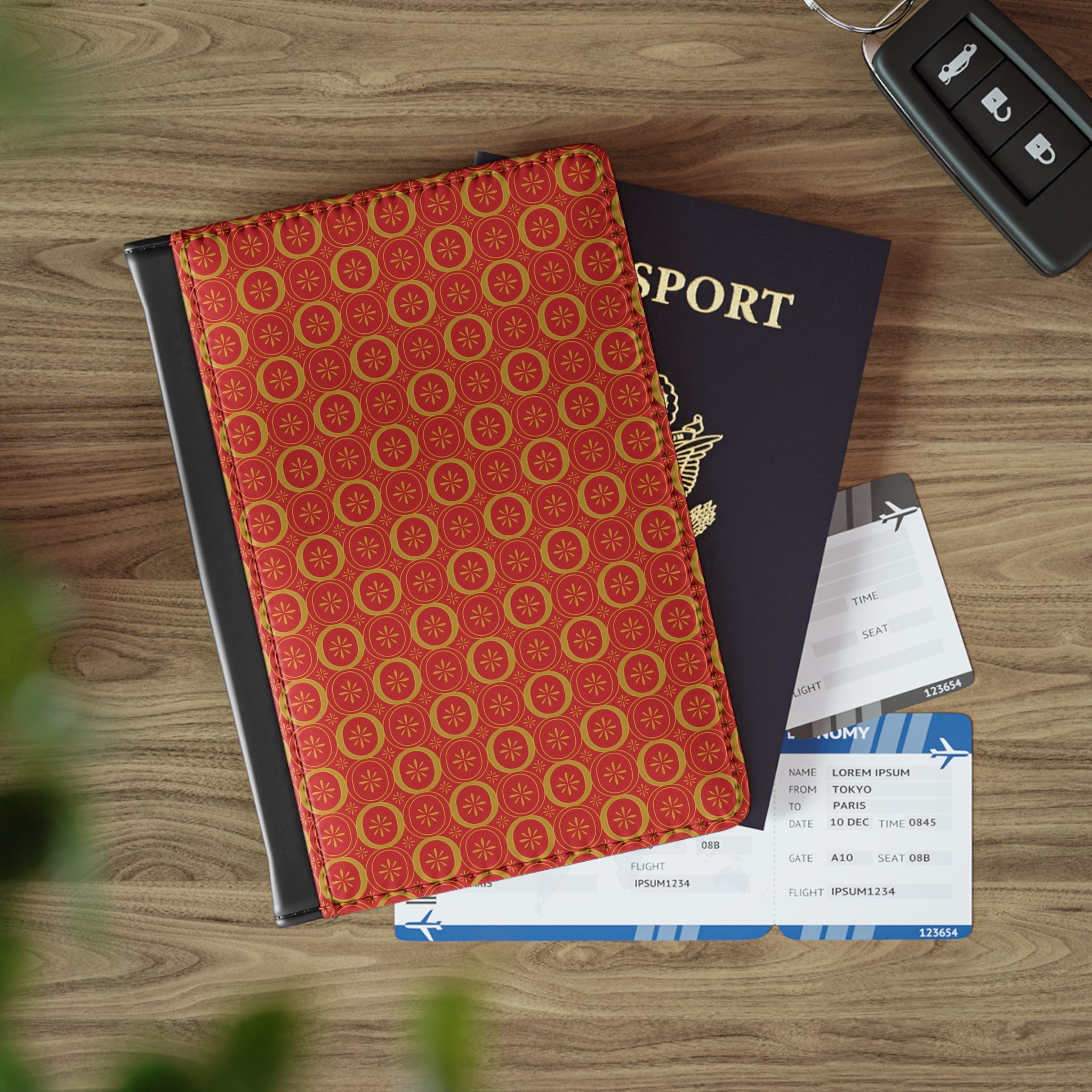Red patterned passport cover, passport, and airplane tickets on a wooden surface