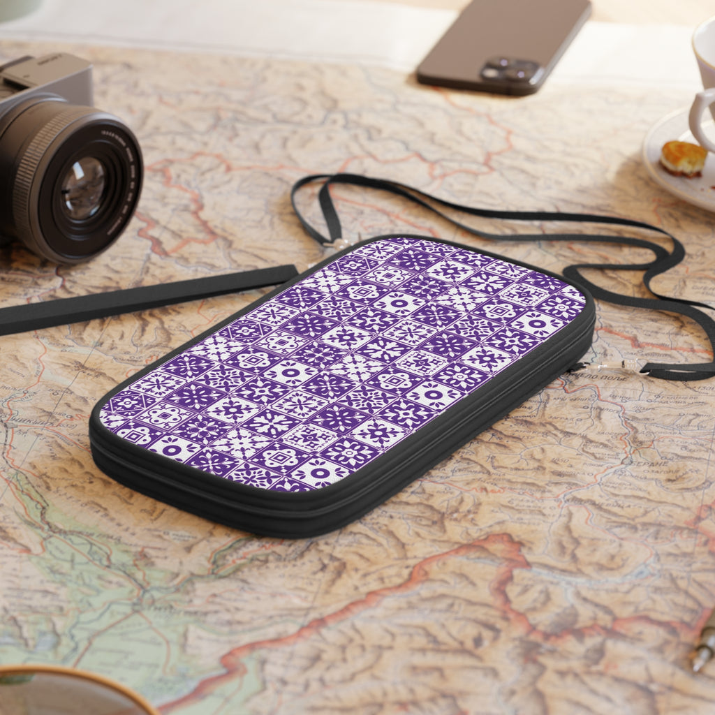 Purple patterned travel wallet on a map with a camera and phone in the background
